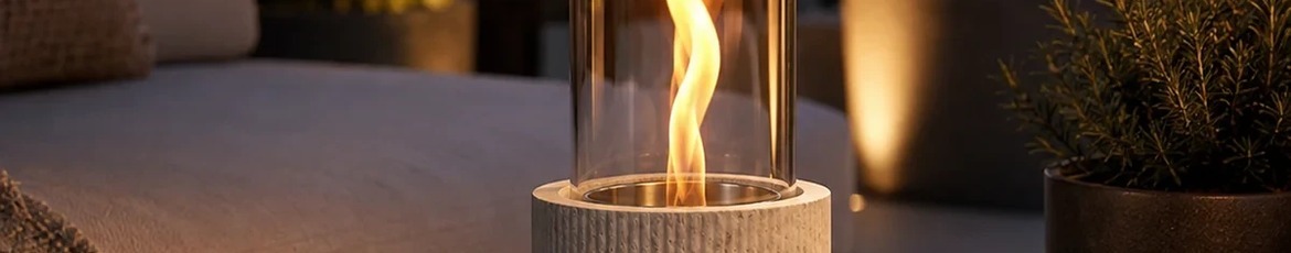 Tenderflame Tischkamin mit Flamme auf einem runden Tisch auf der Terrasse im Abendlicht