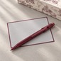 Preview: Caran d'Ache 849 Toile de Jouy Burgundy with grey Crown Mill correspondence card and gift box, background AI visualisation