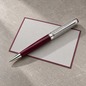 Preview: Caran d'Ache Léman Toile de Jouy Bordeaux Kugelschreiber auf grauer Crown Mill Briefkarte mit bordeauxfarbenem Rand