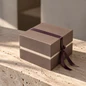 Preview: Embacollage MOKKA Geschenkbox mit Rahmenprägung und auberginefarbenem Geschenkband auf hellem Natursteintisch, elegante Geschenkverpackung