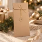 Preview: Embacollage Geschenkumschlag JOY Nature 121 × 260 mm mit goldfarbenem Kordelverschluss, weihnachtlich inszeniert mit Tannenzweig, Geschenk und goldenen Christbaumkugeln