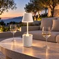 Preview: Sompex PEEKY white rechargeable table lamp on an outdoor table at sunset, background AI visualisation