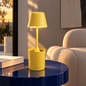 Preview: AI-generated living room scene with yellow Sompex PEEKY rechargeable lamp on a dark blue side table