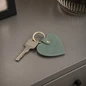 Preview: Trixi Gronau SUNNY Dakar Sage Green key heart with key on a grey sideboard, AI visualisation