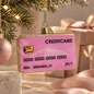 Preview: Vondels pinkfarbene Kreditkarte als Weihnachtsbaumschmuck an einem Tannenzweig