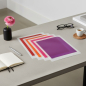 Preview: Julifoli Dokumentenhuelle MONO TREND I, faecherfoermig auf modernem Schreibtisch ausgelegt. Fuenf transparente A4-Sleeves in warmen Farben (pink, rot, orange, rosa, lila) mit rosa Ranunkel und Espresso. Stilvolle Office-Stimmung im Hamburger Concept Store