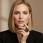 Preview: KMO Ring MONA LISA Statement schwarz am Mittelfinger einer eleganten Frau mit schulterlangem, naturblondem Haar, Hand sanft an Kinn und Hals gelegt. Grosser runder Dome-Ring mit dicht gesetztem anthrazit-schwarzem Pavé auf der oberen Haelfte und silber-bl