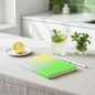 Preview: Nuuna A5 notebook COLOUR CLASH FRESH gradient grey-yellow-neon green on pale linen with lemon slice, fresh lemonade with mint and small green plant in sun-flooded morning kitchen
