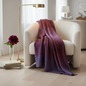 Preview: Oyuna BORDA Cashmere-Tuch amethyst und burgunder Colour-Block weich drapiert über cremefarbenem Bouclé-Sessel mit Tropfenende auf hellem Eichenboden, schlanker Glasvase mit burgunder Pfingstrose, Stapel gedämpfter Kunstbücher und brüniertem Messing-Stehla