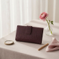 Preview: Trixi Gronau NINA wallet deep aubergine Tejus snake embossed calf leather with tab closure, on blush grey linen with dusty ranunculus, vintage compact mirror, gold pen and pale rose silk handkerchief in airy boudoir
