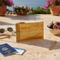 Preview: Trixi Gronau RIZZI Brustbeutel gold Schlangenleder-Prägung mit Reissverschluss und Handschlaufe, auf warmem Travertin mit Reisepass, Boardingpass, Vintage-Sonnenbrille gold, Messingstift und frischen Feigen auf eleganter italienischer Riviera-Terrasse