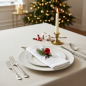 Preview: Trixi Gronau Stoffserviette FROHES FEST weisse Damast-Baumwolle mit dunkelroter Schrift und Adventskranz-Stickerei, auf weihnachtlich modern eingedecktem Tisch mit Tannenzweig, Bauble, Bienenwachskerze und Goldrand-Teller