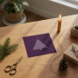 Preview: Trixi Gronau Christmas card GLITTER TREE, square format in deep aubergine with soft lilac glittering minimalist Christmas tree. Styled oak desk arrangement with fir sprig, beeswax candle, brass scissors, jute twine, kraft-paper gift and a potted plant by 