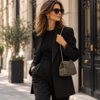 Vimoda Aura Clutch in Oliv an goldfarbener Kette zu schwarzem Outfit getragen, Modell und Hintergrund mit KI erstellt