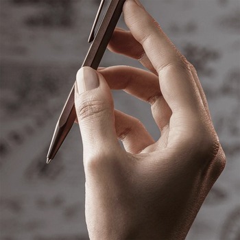 Preview: Caran d'Ache 849 Burgundy ballpoint pen held in hand showing satin finish