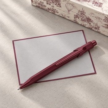 Caran d'Ache 849 Toile de Jouy Burgundy with grey Crown Mill correspondence card and gift box, background AI visualisation