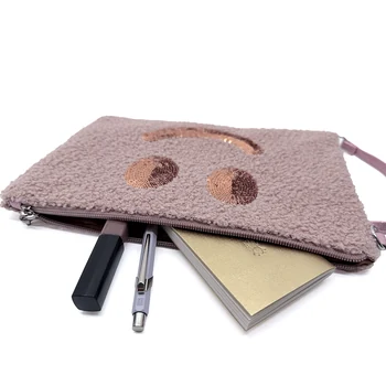 Geöffnete Cute Stuff Clutch in Misty Pink mit Notizbuch, Stift und Lippenstift