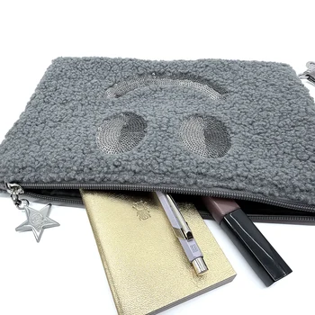 Dunkelgraue Smiley-Clutch mit Reißverschluss und beispielhafter Befüllung