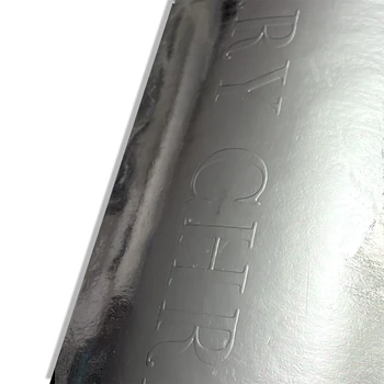 Preview: Nahaufnahme der MERRY CHRISTMAS Blindprägung auf der spiegelnden Silbermetallic-Oberfläche des Embacollage SILVIO Aufklebers