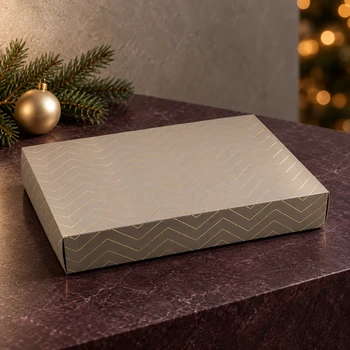 Embacollage GOLDY Faltschachtel mit goldfarbenem Zickzackmuster auf dunklem Tisch, weihnachtlich dekoriert mit Tannenzweig und goldener Christbaumkugel