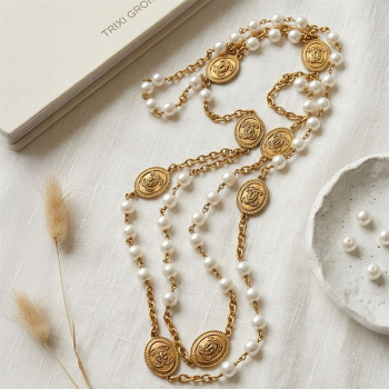 Preview: Interdee, halskette lang, coco, weisse Perlen , mattgoldene florale Medillons, liegend