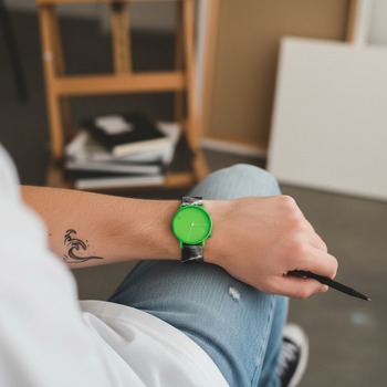Preview: Komono Armbanduhr Lewis Tie Dye am Handgelenk eines jungen kreativen Mannes, neon-grünes Zifferblatt, Tie-Dye-Armband