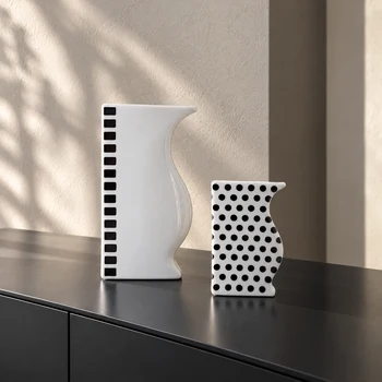 Reichenbach ASTI and ASTA black and white porcelain vases displayed on a dark console