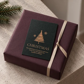 Preview: Kleine dunkelgrüne Weihnachtskarte auf auberginefarben verpacktem Geschenk mit champagnerfarbenem Band