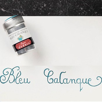 Preview: Jacques Herbin Bleu Calanque Aluminiumdose neben türkisblauer Kalligrafie auf weißem Papier