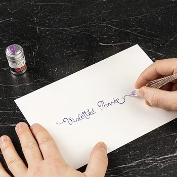 Kalligrafie mit violetter Jacques Herbin Violette Pensée Tinte und Glasfeder auf weißem Papier
