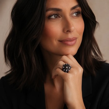 Preview: KMO BLACK PEARLS cocktail ring, a large statement ring with dark pavé surface and grey freshwater pearls set into the dome, worn on the hand of a brunette in a black blazer. Refined cocktail elegance with pearl accent. Trixi Gronau Concept Store, Hamburg.