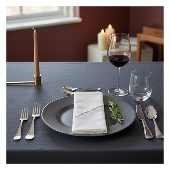 Preview: Trixi Gronau Stoffserviette DINNER WITH FRIENDS weisse Damast-Baumwolle mit dunkelgrauer Schrift-Stickerei, auf modernem Abendtisch mit anthrazit Charger-Teller, Silberbesteck, Rotweinglas und Kerze in eleganter Dinner-Atmosphäre