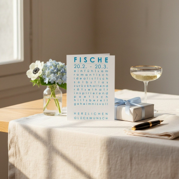 Preview: Trixi Gronau Sternzeichenkarte FISCHE, A6 Hochformat in zartem Cyan-Blau mit elegantem Typografie-Layout und Geburtstagsgruss HERZLICHEN GLUECKWUNSCH. Aufgestellt auf einem hellen Eichen-Schreibtisch mit cremefarbener Leinen-Decke, daneben hellblaue Horte