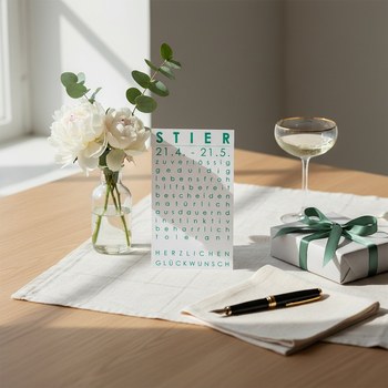 Preview: Trixi Gronau Sternzeichenkarte STIER, A6 Hochformat in Smaragdgruen mit elegantem Typografie-Layout und Geburtstagsgruss HERZLICHEN GLUECKWUNSCH. Auf hellem Eichen-Schreibtisch mit cremefarbener Leinen-Decke, daneben weisse Pfingstrosen und frische gruene