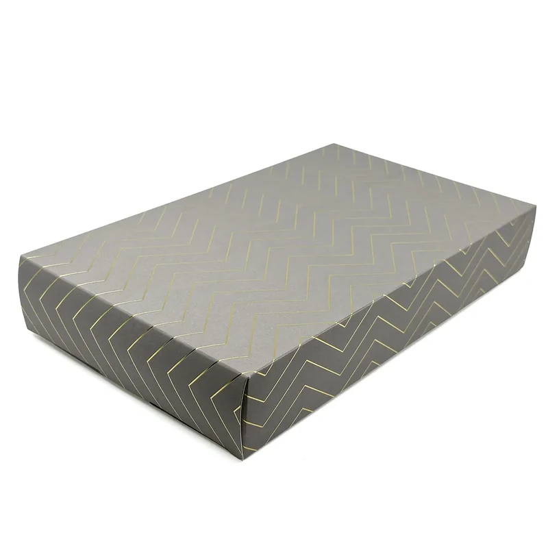 Embacollage GOLDY Geschenkbox aus Karton in schräger Seitenansicht mit taupefarbener Oberfläche und goldfarbenem geometrischem Linienmuster