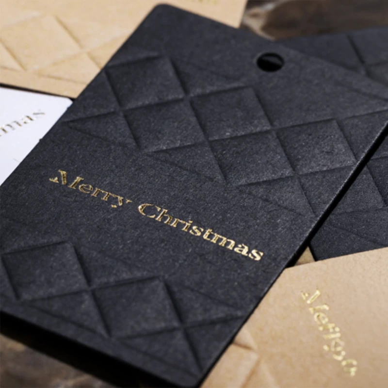 Nahaufnahme schwarzer Embacollage Merry Christmas Geschenkanhänger mit plastischer Rautenprägung und goldfarbenem Schriftzug