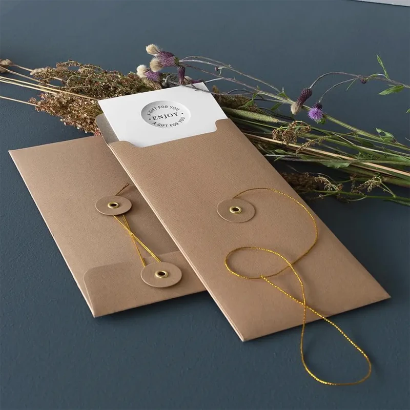Zwei Embacollage Geschenkumschläge JOY Nature in natur mit goldfarbener Kordel auf dunkelblauem Grund mit Trockenblumen, TRIXI GRONAU Hamburg