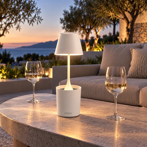 Sompex PEEKY white rechargeable table lamp on an outdoor table at sunset, background AI visualisation
