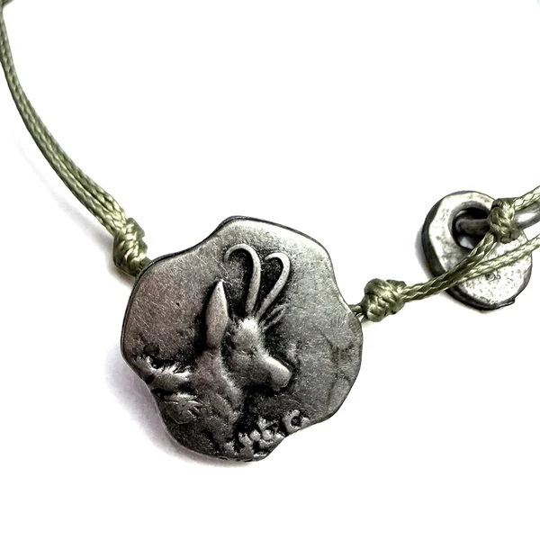 Unregelmäßiges altsilberfarbenes Hirschemblem am grünen Kordelarmband von S Punkt Spangemacher