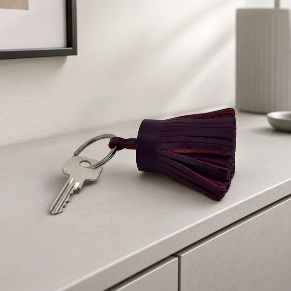 Trixi Gronau key fob leather tassel LOTTA aubergine with key on a sideboard, AI visualisation