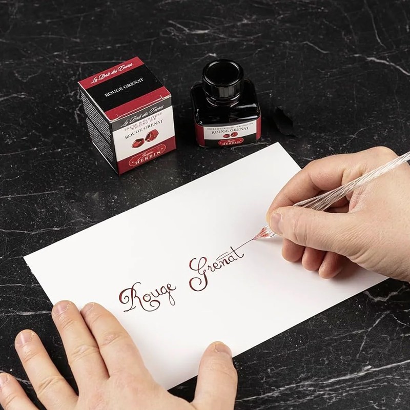 Kalligrafie mit Jacques Herbin Rouge Grenat Tinte und Glasfeder auf weißem Papier