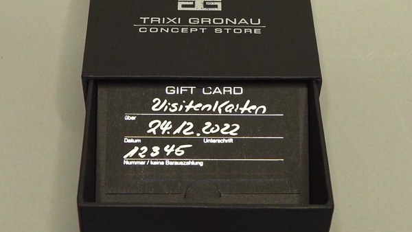 Opened black gift box with Trixi Gronau gift card in business card format, silver hot foil embossing