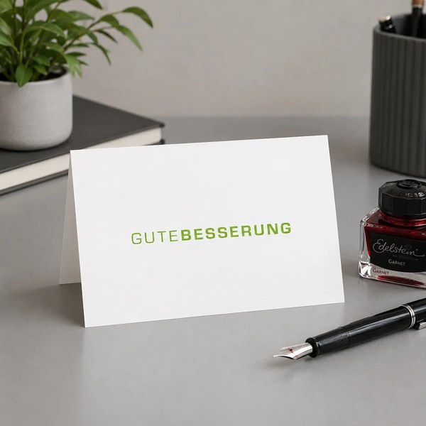 Trixi Gronau GUTE BESSERUNG get-well greeting card, B6 landscape in white paper with the words GUTE BESSERUNG in large fresh-green sans-serif capitals, GUTE in fine weight and BESSERUNG in heavier weight, centered almost across the full card width. On a l