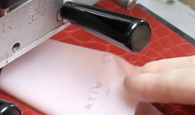Baier embossing press working on red leather in the TRIXI GRONAU workshop