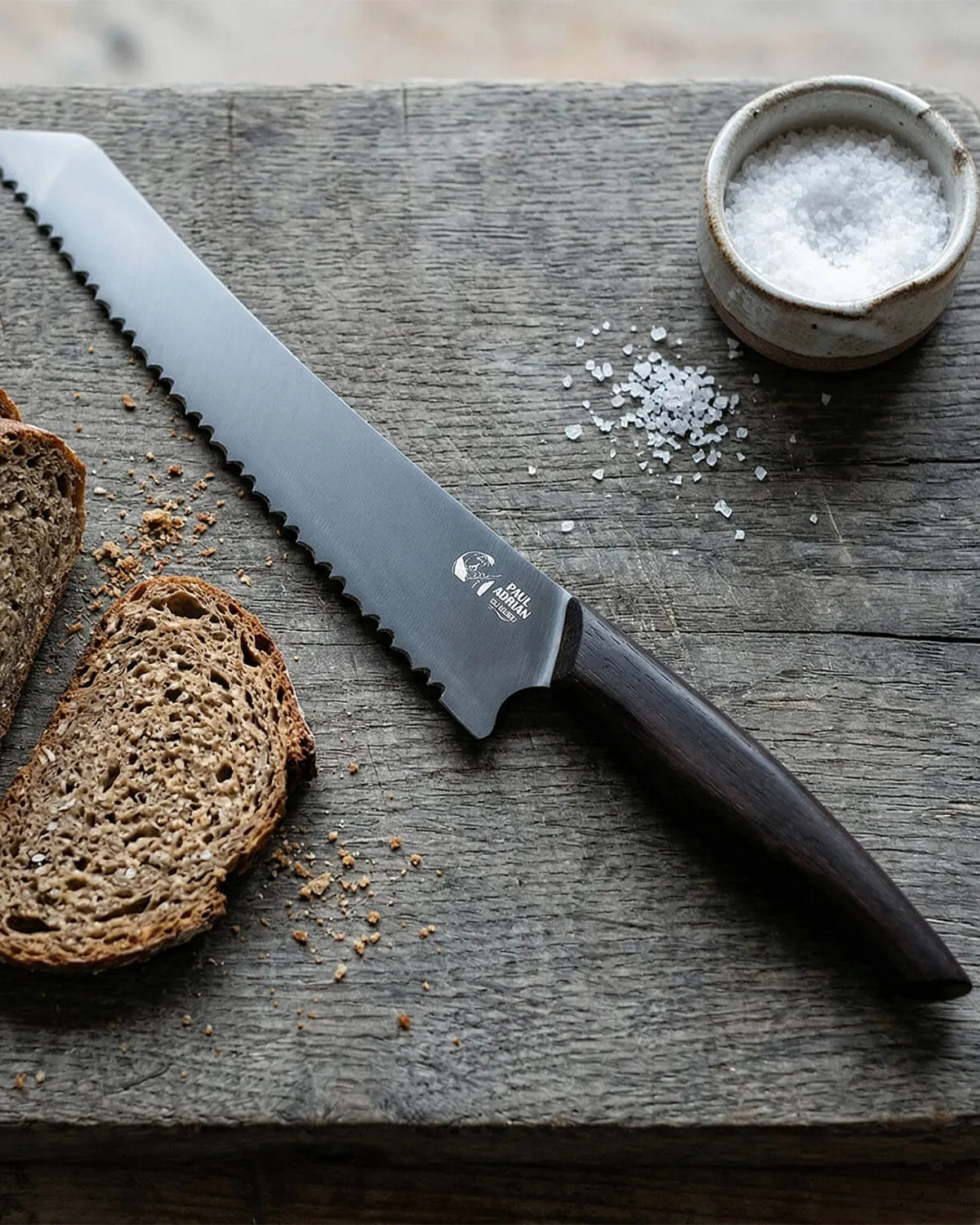 Paul Adrian bread knife on a wooden board with slices of bread and salt as a gift idea for men