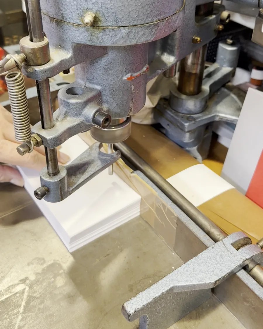 Papierstapel unter dem Bohrer einer Papierbohrmaschine