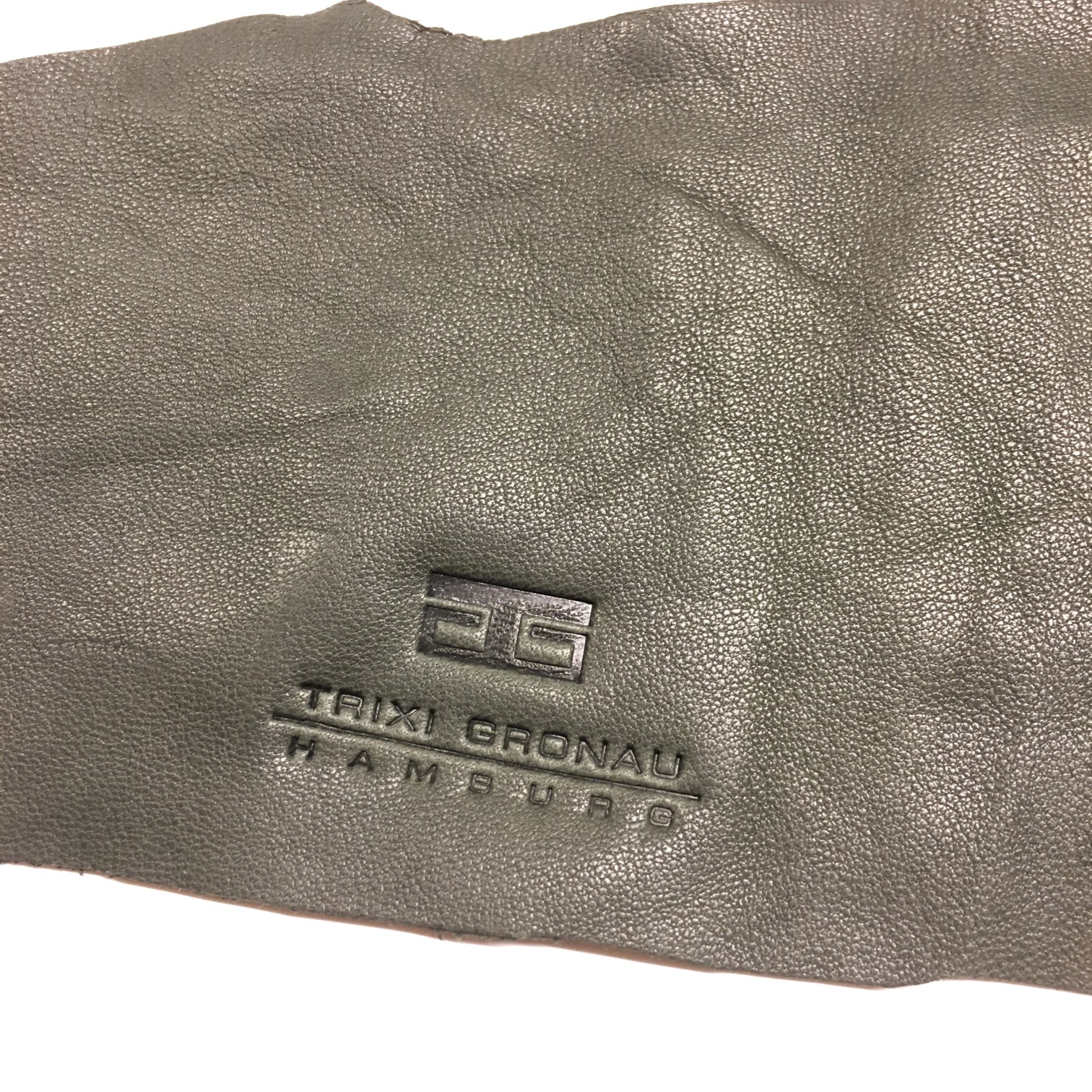 Graugrünes Leder mit feiner Narbung und eingeprägtem Logo TRIXI GRONAU HAMBURG