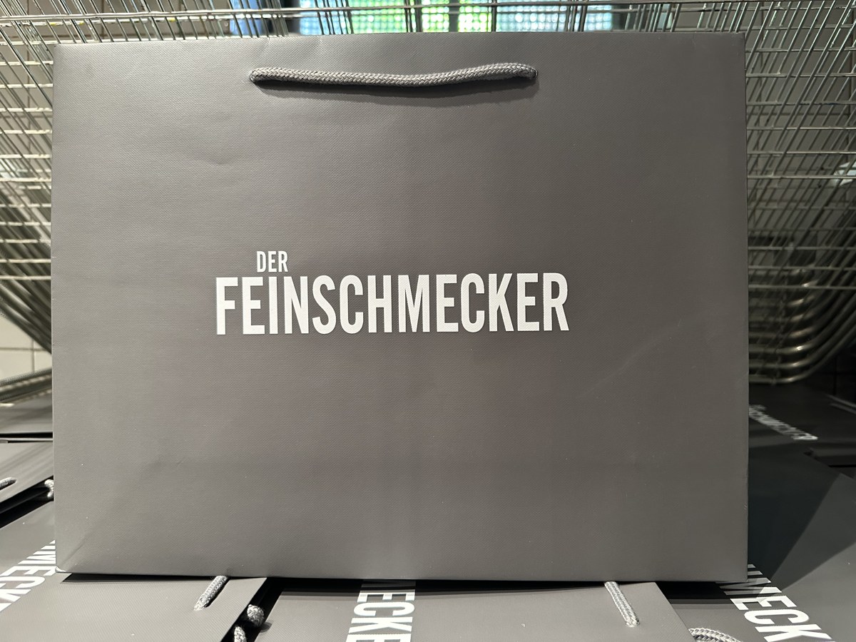 Finished grey carrier bag with white Der Feinschmecker lettering and a cord handle