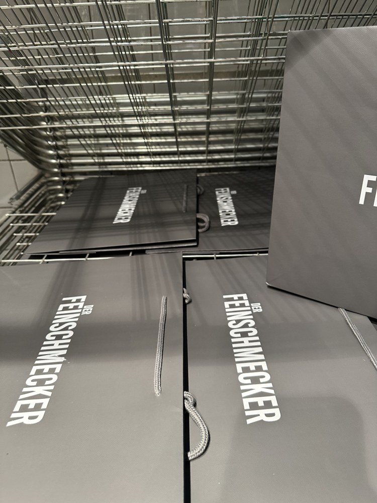 Printed grey carrier bags laid out to dry on a wire rack
